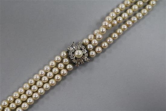 A triple strand cultured pearl choker necklace with 9ct white gold and gem set clasp, 30cm.